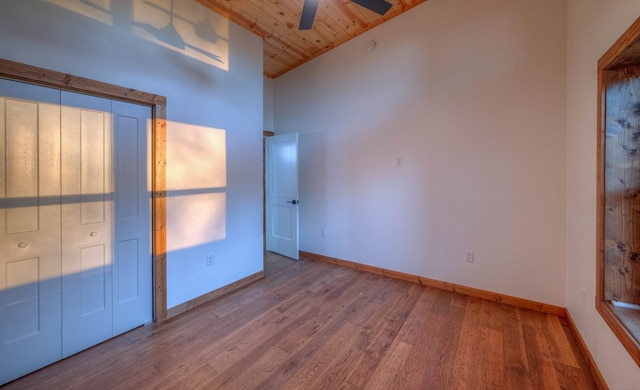 unfurnished bedroom featuring wooden ceiling, hardwood / wood-style flooring, ceiling fan, high vaulted ceiling, and a closet