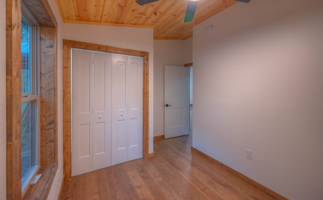 unfurnished bedroom with a closet, vaulted ceiling, light hardwood / wood-style floors, wooden ceiling, and ceiling fan