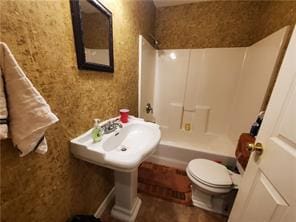 bathroom featuring toilet and bathing tub / shower combination