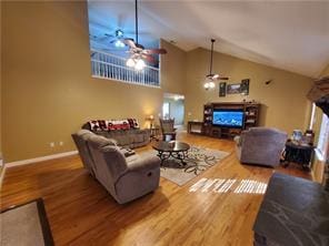 living room with ceiling fan, high vaulted ceiling, and hardwood / wood-style floors