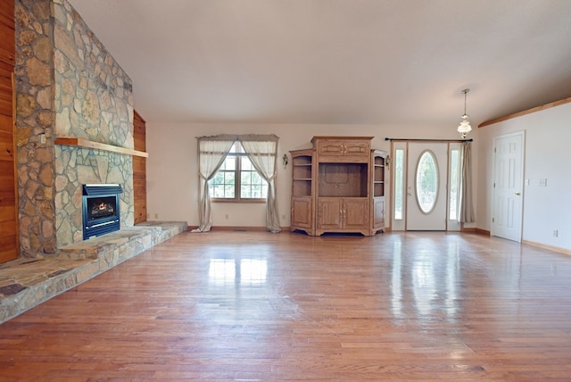 unfurnished living room featuring a stone fireplace and wood-type flooring