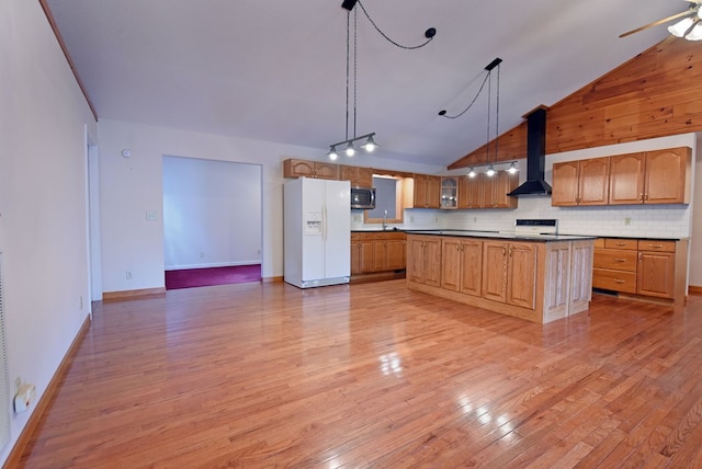 kitchen featuring white refrigerator with ice dispenser, high vaulted ceiling, hanging light fixtures, wall chimney exhaust hood, and tasteful backsplash