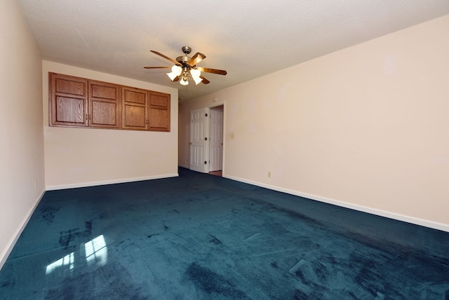 carpeted empty room featuring ceiling fan and a textured ceiling