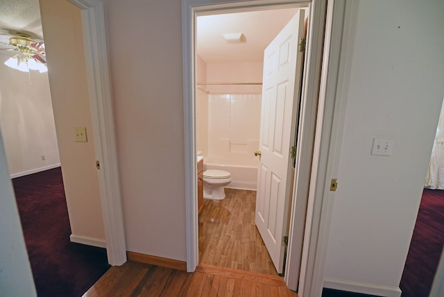 hallway featuring wood-type flooring and a textured ceiling