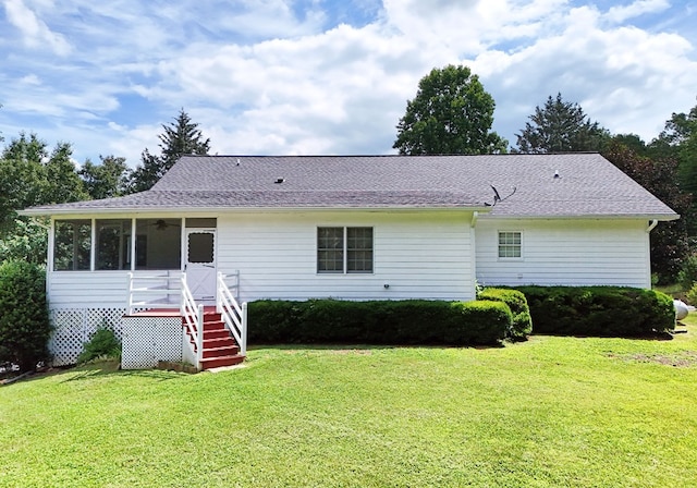 view of front of house featuring a sunroom and a front yard