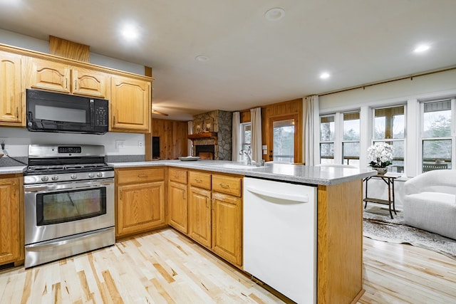 kitchen with dishwasher, stainless steel gas range oven, kitchen peninsula, and sink