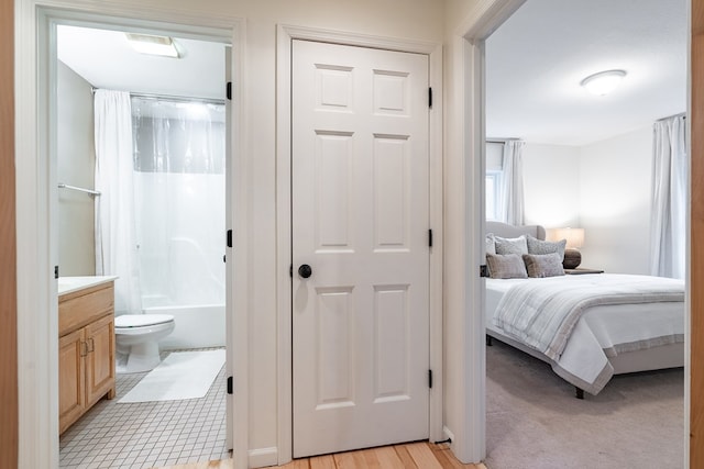 bedroom featuring ensuite bathroom and light hardwood / wood-style flooring