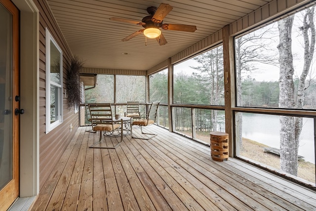 unfurnished sunroom featuring ceiling fan