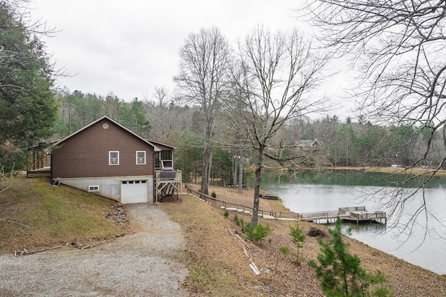 view of side of property featuring a sunroom, a garage, and a water view