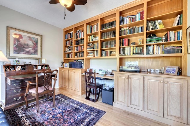 office with a textured ceiling, light hardwood / wood-style floors, ceiling fan, and built in desk