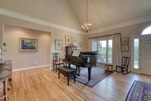 miscellaneous room featuring an inviting chandelier, light wood-type flooring, high vaulted ceiling, and ornamental molding