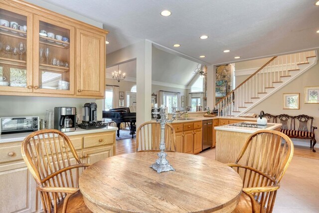 dining space featuring lofted ceiling, sink, light hardwood / wood-style flooring, a chandelier, and crown molding