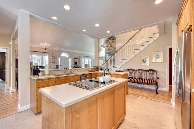 kitchen with sink, an island with sink, stainless steel refrigerator, light hardwood / wood-style flooring, and crown molding