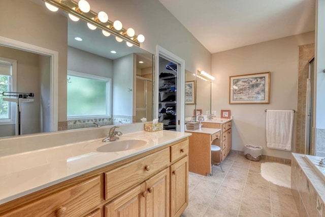 bathroom featuring vanity, plus walk in shower, tile patterned flooring, and a wealth of natural light