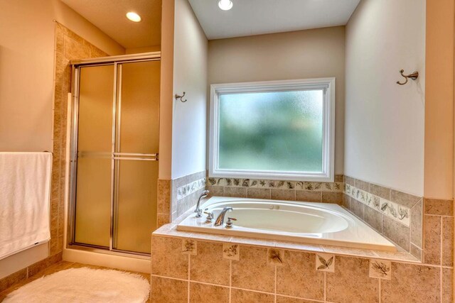 bathroom featuring shower with separate bathtub