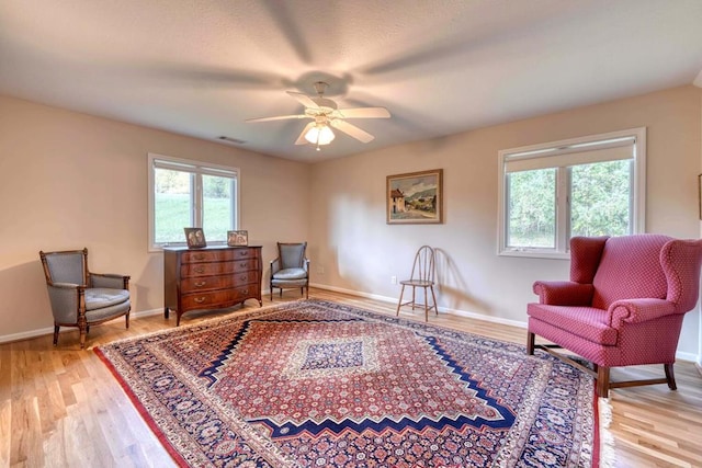 sitting room with ceiling fan and light hardwood / wood-style flooring