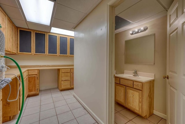 bathroom featuring tile patterned floors, vanity, and a paneled ceiling