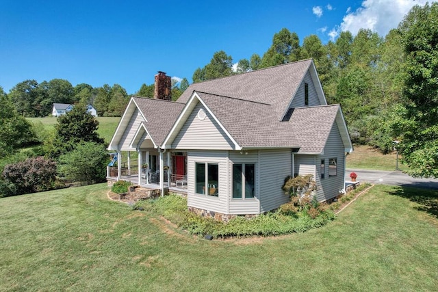 back of property featuring a porch and a lawn