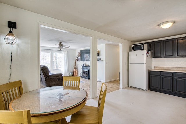 211 Gregory Hollow Rd, Robbinsville, NC 28771 - dining space with a fireplace, baseboards, light floors, and ceiling fan