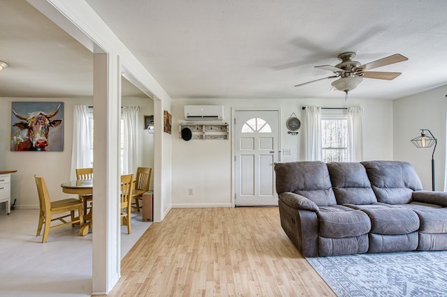 211 Gregory Hollow Rd, Robbinsville, NC 28771 - living room featuring light wood finished floors, baseboards, a wall unit AC, and ceiling fan
