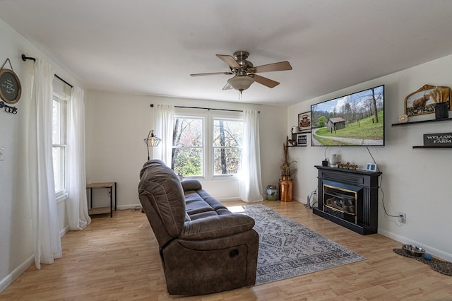 211 Gregory Hollow Rd, Robbinsville, NC 28771 - living area featuring light wood-style flooring, ceiling fan, baseboards, and a glass covered fireplace