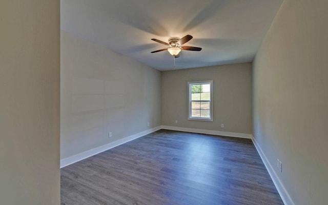 spare room featuring a ceiling fan, baseboards, and dark wood finished floors