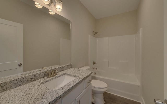 full bathroom featuring toilet, vanity, wood finished floors, and  shower combination
