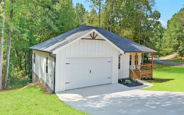 detached garage featuring a porch and concrete driveway