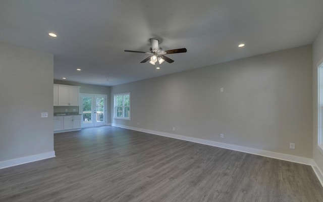 unfurnished living room featuring recessed lighting, wood finished floors, a ceiling fan, and baseboards