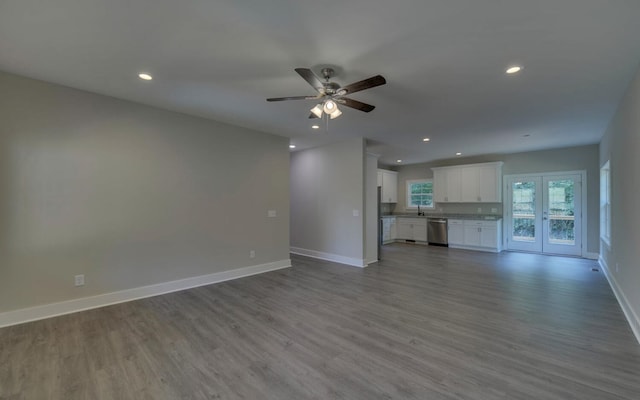 unfurnished living room featuring sink, hardwood / wood-style flooring, french doors, and ceiling fan