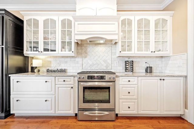 kitchen featuring electric range, tasteful backsplash, light wood-style flooring, and crown molding