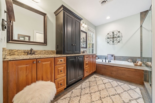 bathroom featuring double vanity, a garden tub, tile patterned floors, and a sink