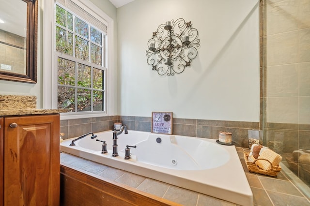 full bath with a wealth of natural light, a tub with jets, and a chandelier