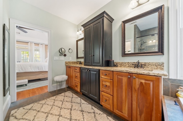 ensuite bathroom featuring visible vents, ceiling fan, double vanity, ensuite bathroom, and a sink