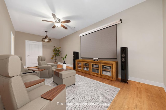 home theater featuring visible vents, baseboards, light wood finished floors, and ceiling fan