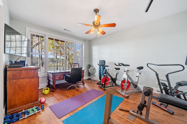 workout area featuring visible vents, baseboards, wood finished floors, and a ceiling fan