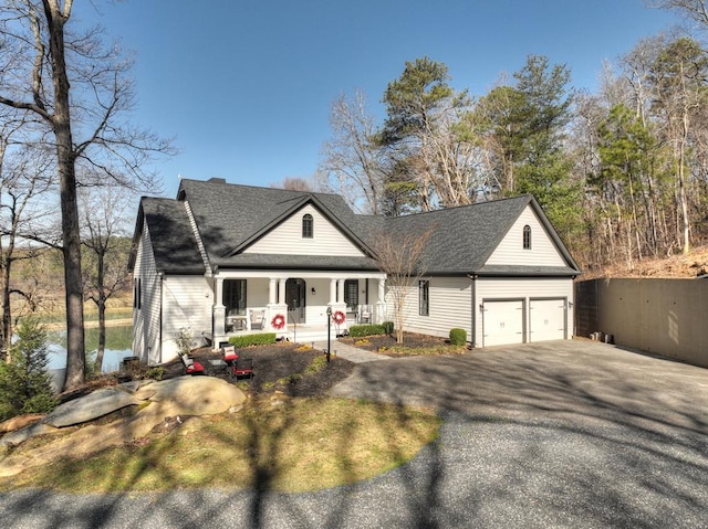 view of front of property featuring aphalt driveway, roof with shingles, covered porch, and an attached garage