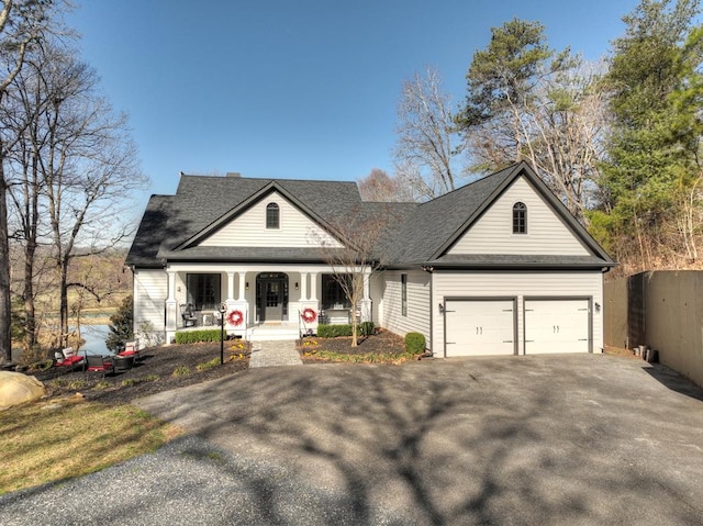 view of front of property featuring aphalt driveway, a porch, an attached garage, and roof with shingles