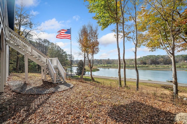 view of yard with stairs and a water view