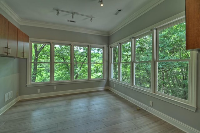 unfurnished sunroom with rail lighting