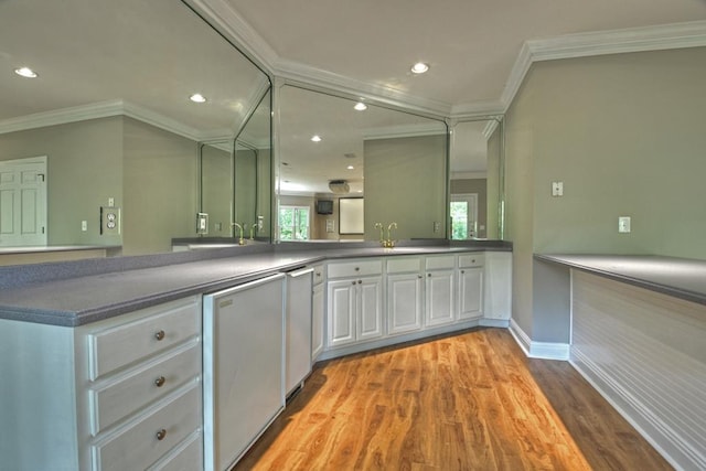 bar featuring white cabinetry, sink, refrigerator, light hardwood / wood-style floors, and ornamental molding