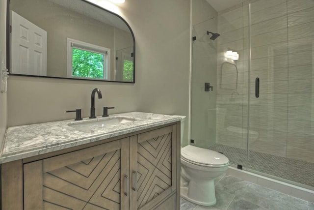 bathroom featuring tile patterned floors, vanity, toilet, and a shower with shower door