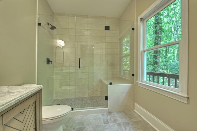 bathroom featuring vanity, toilet, and a shower with shower door