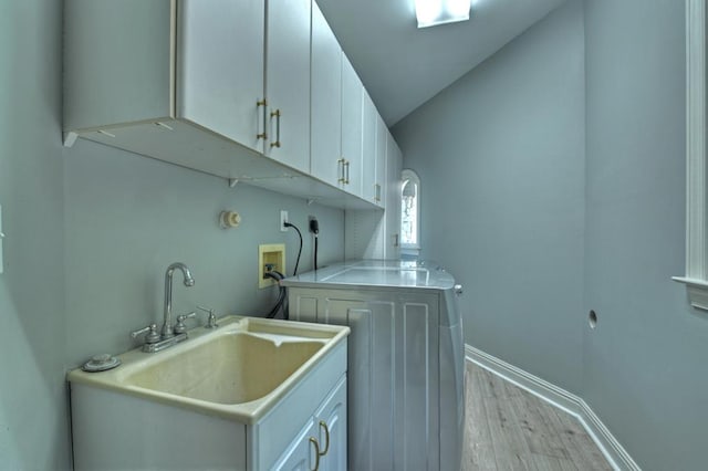 clothes washing area featuring sink, cabinets, electric dryer hookup, hookup for a washing machine, and light wood-type flooring