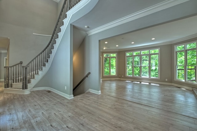 unfurnished living room featuring light wood-type flooring and crown molding