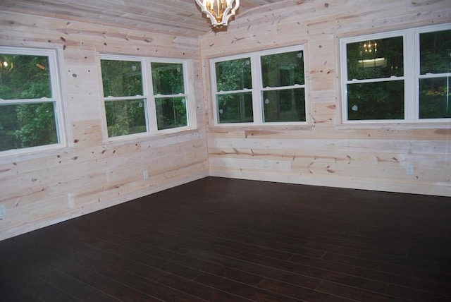 spare room featuring wooden walls and hardwood / wood-style flooring