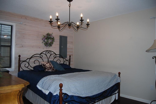 bedroom featuring a notable chandelier, wooden walls, and electric panel