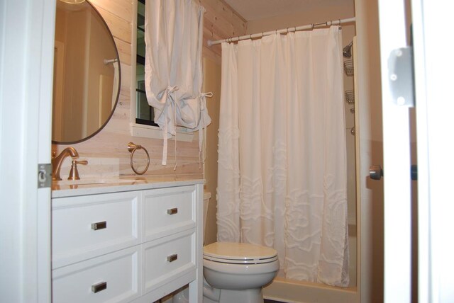 bathroom with walk in shower, vanity, and toilet