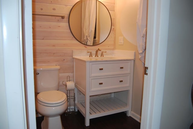 bathroom featuring wood walls, vanity, toilet, and hardwood / wood-style flooring