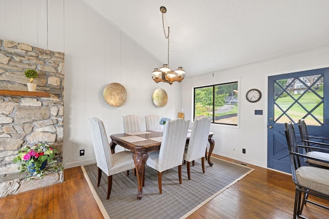 2793 Hidden Valley Rd, Hiawassee, GA 30546 - dining area featuring wood-type flooring, vaulted ceiling, a chandelier, and a decorative wall